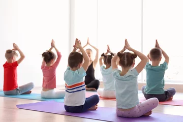 Gordijnen Little children and their teacher practicing yoga in gym © New Africa