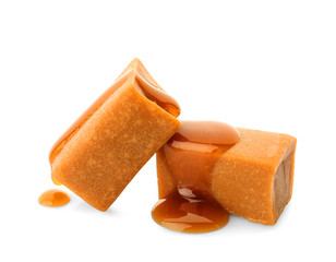 Delicious candies with caramel sauce on white background