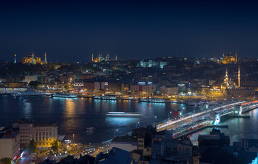 Long exposure cityscape of Istanbul at a night. Galata bridge on Golden Horn gulf. Wonderful romantic old town at Sea of Marmara. Bright light of street lighting and various ships. Istanbul. Turkey.