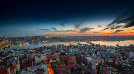Fototapeta na wymiar Long exposure panoramic cityscape of Istanbul at a beautiful dramatic clouds sunset from Galata to Golden Horn gulf. View of the wonderful romantic old town at Sea of Marmara. Istanbul. Turkey.