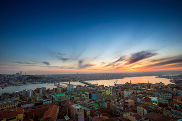 Fototapeta na wymiar Long exposure panoramic cityscape of Istanbul at a beautiful dramatic clouds sunset from Galata to Golden Horn gulf. View of the wonderful romantic old town at Sea of Marmara. Istanbul. Turkey.