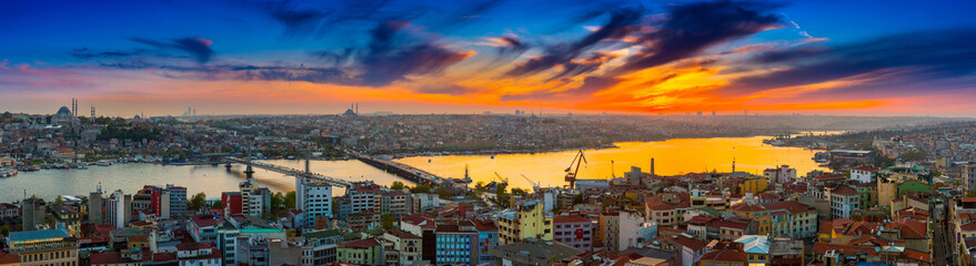 Long exposure panoramic cityscape of Istanbul at a beautiful dramatic clouds sunset from Galata to Golden Horn gulf. View of the wonderful romantic old town at Sea of Marmara. Istanbul. Turkey.