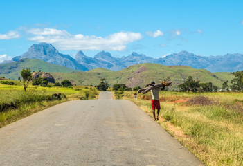 Fototapeta na wymiar Barefooted Bara people walk long distances along the legendary National Route 7 to trade their goods in the southern part of the central plateau of Madagascar.