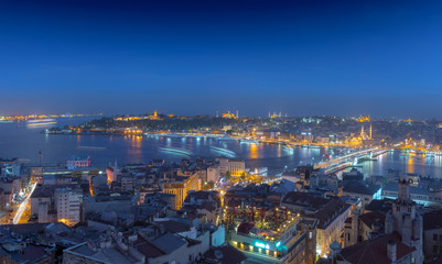 Fototapeta na wymiar Long exposure panoramic cityscape of Istanbul at a warm calm evening from Galata to Golden Horn gulf. Wonderful romantic old town at Sea of Marmara. Bright light of street lighting. Istanbul. Turkey.