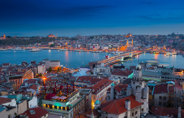 Obraz premium Long exposure panoramic cityscape of Istanbul at a warm calm evening from Galata to Golden Horn gulf. Wonderful romantic old town at Sea of Marmara. Bright light of street lighting. Istanbul. Turkey.