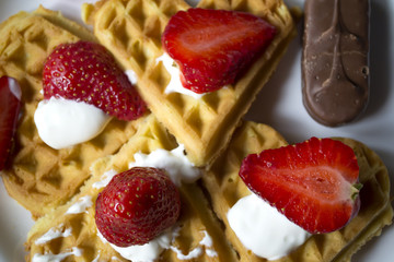 Ripe strawberry on waffles close up. Beautiful and tasty breakfast.
