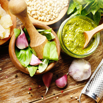 Top view of Pesto sauce ingredients and utensils on wood table with copy-space