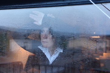 Woman looking out the window on a rainy day