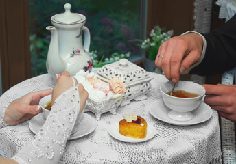 The bride and groom sitting at the table in the cafe and drinking tea