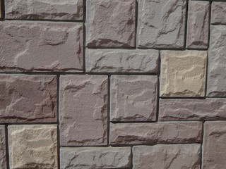 Beautiful tiles on the facade of the building. Background and texture of a colorful wall. Facing with tiles or decorative finishing stones. The design of the facade of the wall is colored stone.