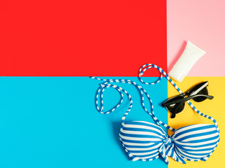 summer accessories and minimal flat lay concept from bikini, cloth and vacation item decorate on pastel and colorful background