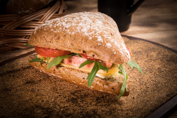 Triangular sandwich with cheese, ham and tomato.