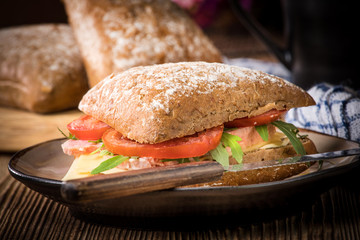 Triangular sandwich with cheese, ham and tomato.