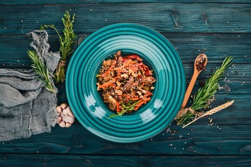 Risotto with veal and vegetables. On a wooden background. Chinese cuisine. Top view. Copy space.