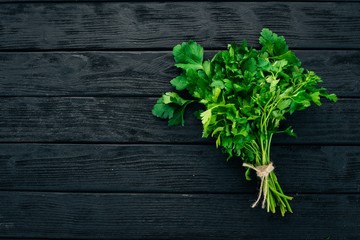 Fresh parsley. On a black wooden background. Healthy food. Top view. Copy space.