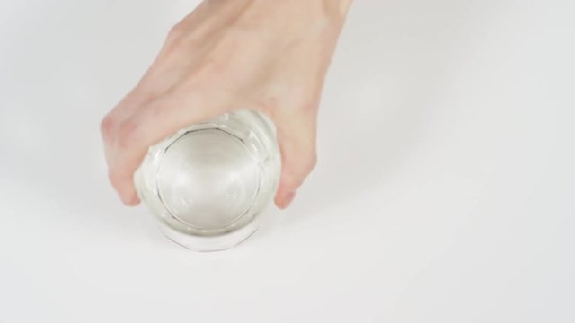 Hand taking a glass of water and a pill