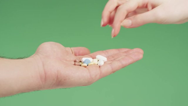 Taking a pill from a hand with various meds