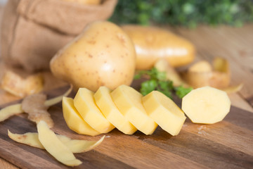 Potatoes on a cutting board sliced into pieces.