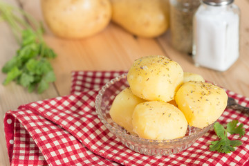 Boiled potato with oregano and salt on glass bowl.