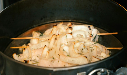 Chicken meat on wooden skewer in oven.
