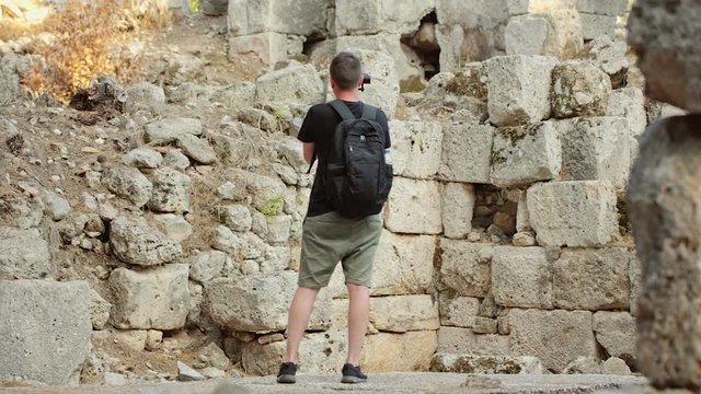 A traveler shoots video footage in the Ruins of the Antique City