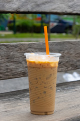 Coffee cool moment the sun is low. On a wooden chair in the park