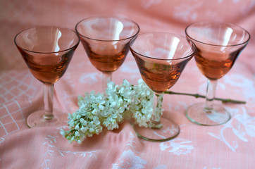 brown glasses on pink background and white lilac flowers