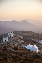 A series of deserted windmills and a small chapel at the top of Chora of Amorgos through a windmill...