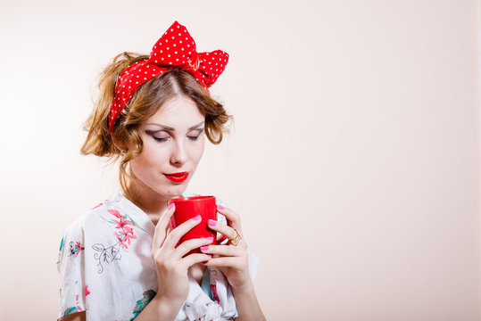 closeup portrait on beautiful funny pinup blond young woman with red lips having fun drinking tea happy smiling looking at camera and showing biceps muscles on white background picture