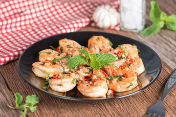 Stir-fried Shrimp with pepper and garlic on black plate.