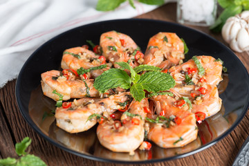 Stir-fried Shrimp with pepper and garlic on black plate.