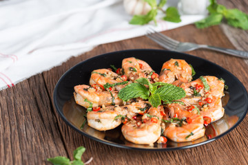 stir-fried Shrimp with pepper and garlic on black plate.