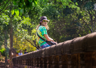 Young traveler wearing a hat with backpack and tripod - at Angkor Wat, Siem Reap, Cambodia