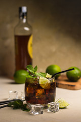 Cuba Libre drink with mint leaves and pieces of lime.