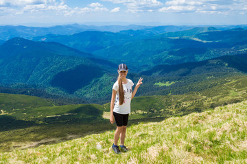 Naklejka na ściany i meble Young happy woman on top of hill enjoy beautiful view of sky and mountains, freedom and harmony concept