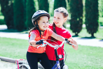 Obraz premium older sister teaches to ride a bicycle outdoors