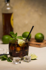 Cuba Libre drink with mint leaves and pieces of lime.