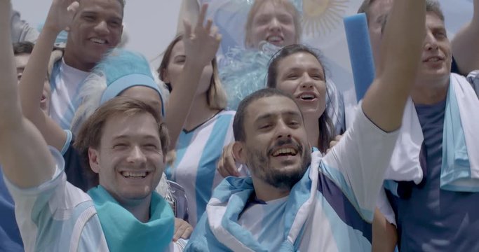 Group of Argentinian football fans cheering at football match