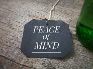 Motivational and inspirational quote - ‘Peace of mind’ written on a black piece of paper. Vintage styled background.