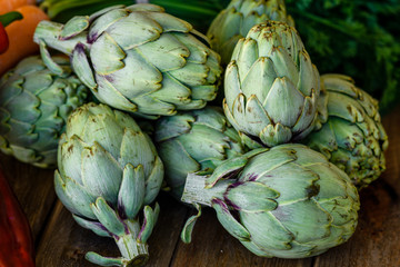 Obraz premium artichokes, peppers and carrots on wooden table