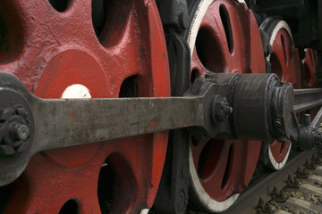 Obraz na płótnie Canvas wheels of an old functioning steam locomotive with drawbar and crank mechanism closeup