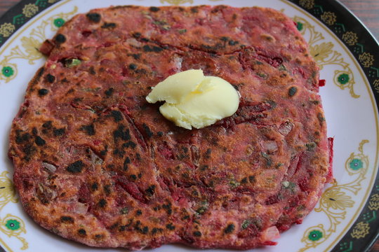 Close up of Beetroot paratha with pasteurised butter