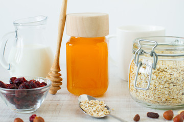 Food background of homemade granola with yogurt, nuts, dried fruits and honey on white table for healthy breakfast