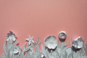 3d paper flowers with painted leaves and stems on the pink background