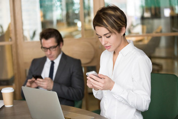 Fototapeta premium Businesswoman and businessman using mobile phones for work during meeting break, office people holding corporate gadgets working with business apps, employees communicating online on smartphones