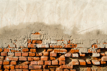 Partly plastered old brick wall