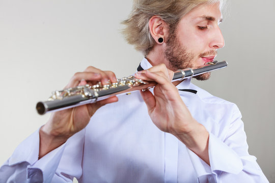 Male flutist playing his flute