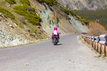 motorcyclist rides in the mountains on the road