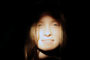 Woman with pretty face smile in sunny light. Sensual woman with blond long hair on dark background....