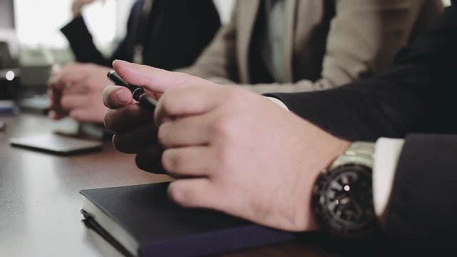 Pens in the hands of business people. A business meeting.